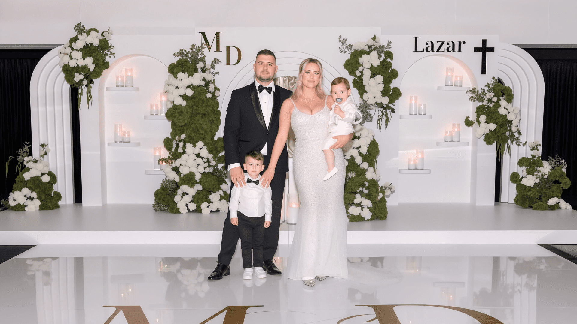 Wedding backdrop decor with green and white floral arrangements, candles, draping, backdrop stage and custom dance floor with initials by Colourful Treasures