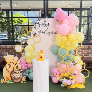 Winnie the Pooh baby shower styling with custom character props, balloon garland and ripple cake stand by Colourful Treasures
